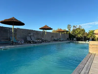 a swimming pool with chairs and umbrellas at Villa A CASA DI LO in Lecci