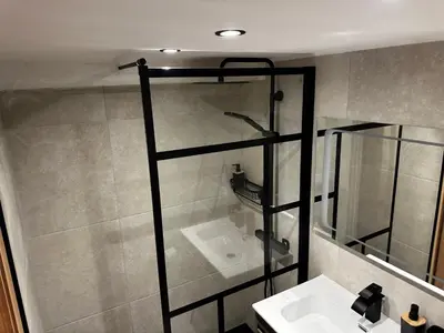 a bathroom with a sink and a glass shower at Appartement U Diu Grossu in Bonifacio