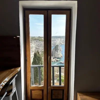 an open door with a view of the ocean at Appartement U Diu Grossu in Bonifacio