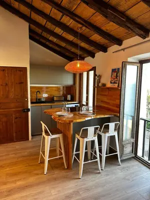 a kitchen with a large island with white bar stools at Appartement U Diu Grossu in Bonifacio
