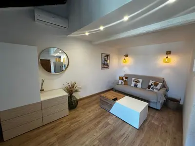a living room with a couch and a mirror at Appartement U Diu Grossu in Bonifacio