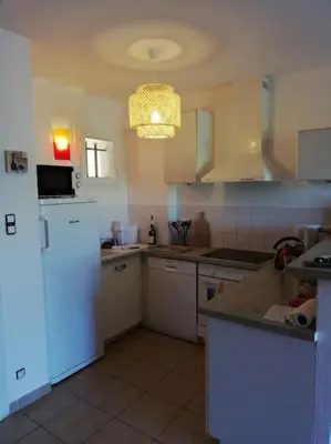 a kitchen with white appliances and a white refrigerator at T3 en rdj pour 6 pers dans résidence avec piscine in Propriano