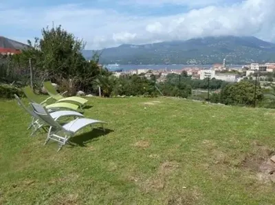 a row of lawn chairs sitting on top of a field at T3 en rdj pour 6 pers dans résidence avec piscine in Propriano