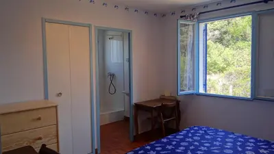 a bedroom with a bed and a window and a desk at Residence Funtanella in Sagone