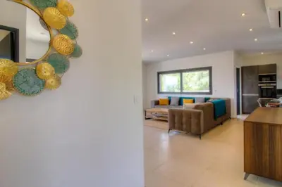 a living room with a couch and a mirror at Villa Stella avec piscine entre mer et rivière in Vardiola
