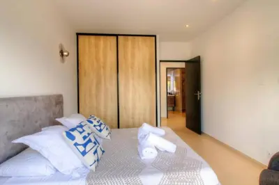 a bedroom with a bed with blue and white pillows at Villa Stella avec piscine entre mer et rivière in Vardiola