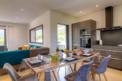 a kitchen and living room with a table and chairs at Villa Stella avec piscine entre mer et rivière in Vardiola