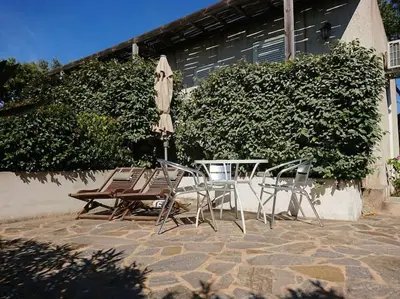 two chairs and a table and an umbrella on a patio at Studio à 5 minutes à pied du centre ville de Porto Vecchio in Porto-Vecchio
