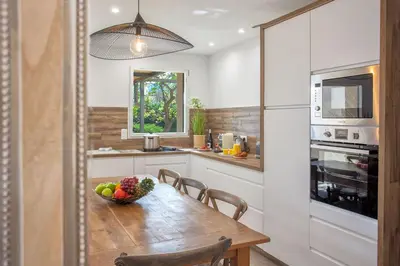 a kitchen with a wooden table with a bowl of fruit at Villa 