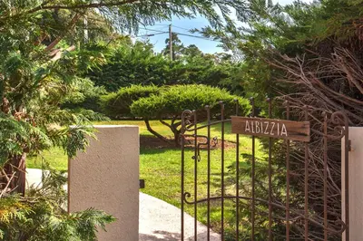 a gate to a garden with a sign on it at Villa 
