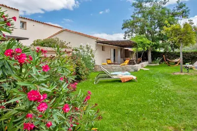 a yard with pink flowers and a house at Villa 