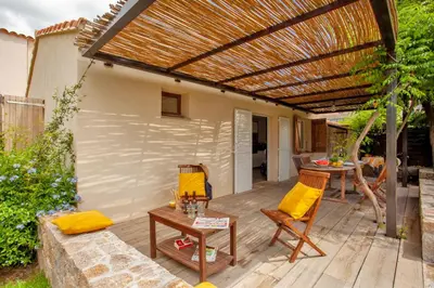 a patio with a pergola and a table and chairs at Villa 