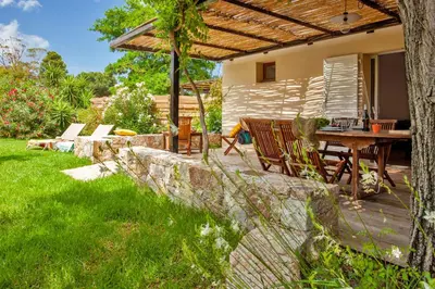 a patio with a table and chairs under a pergola at Villa 