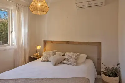 a bedroom with a bed with white sheets and pillows at Maisonnette une chambre 