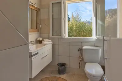 a bathroom with a toilet and a window at Maisonnette une chambre 