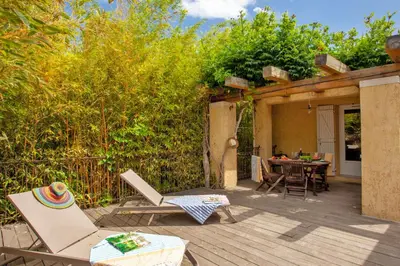 a patio with chairs and a table in a yard at Maisonnette 