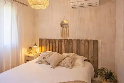 a bedroom with a large white bed with pillows at Maisonnette 