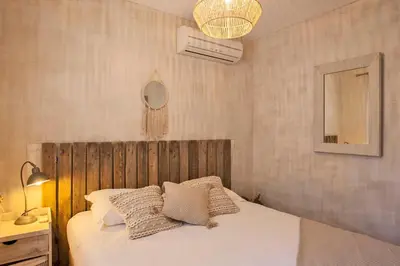 a bedroom with a bed with white sheets and pillows at Maisonnette 