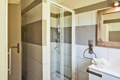 a bathroom with a shower and a sink at Maisonnette 