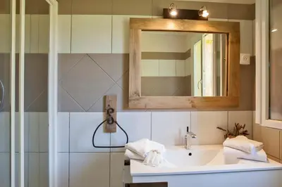 a bathroom with a sink and a mirror at Maisonnette 