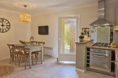 a kitchen with a table and a dining room at Maisonnette 