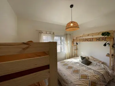 a bedroom with a wooden bed and a pendant light at Vista Mare- proche plage et commerces - 8 pers in Sari Solenzara