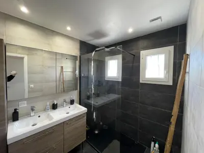 a bathroom with a sink and a shower and a mirror at Vista Mare- proche plage et commerces - 8 pers in Sari Solenzara