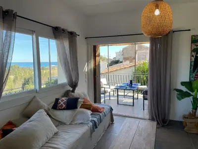 a living room with a couch and large windows at Vista Mare- proche plage et commerces - 8 pers in Sari Solenzara