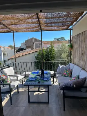 a patio with a couch and a table on a balcony at Vista Mare- proche plage et commerces - 8 pers in Sari Solenzara