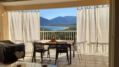a table and chairs in a room with a large window at Villa T4 à Campomoro corse du sud, 800m plage in Belvédère