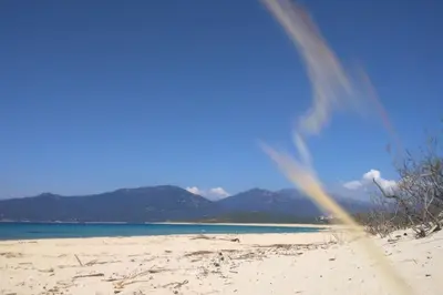 a rainbow on a beach with mountains in the background at Villa T4 à Campomoro corse du sud, 800m plage in Belvédère