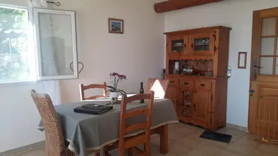 a dining room with a table and a wooden cabinet at Villa T4 à Campomoro corse du sud, 800m plage in Belvédère