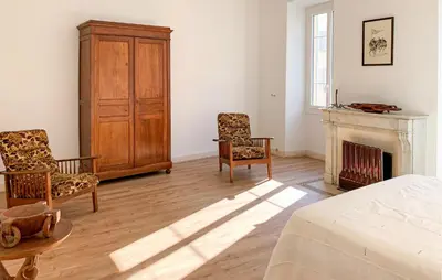 a bedroom with a bed and two chairs and a fireplace at Awesome Apartment In Ajaccio With Wifi in Ajaccio