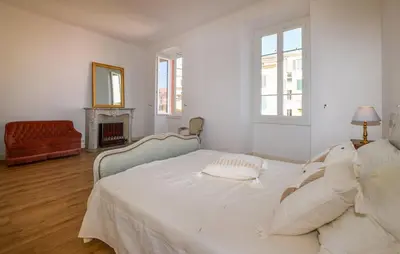 a white bedroom with a bed and a fireplace at Awesome Apartment In Ajaccio With Wifi in Ajaccio