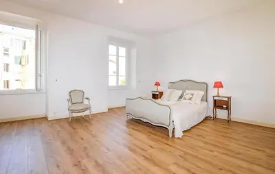 a white bedroom with a bed and a chair at Awesome Apartment In Ajaccio With Wifi in Ajaccio