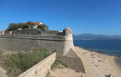 a stone wall next to a beach and the ocean at Awesome Apartment In Ajaccio With Wifi in Ajaccio