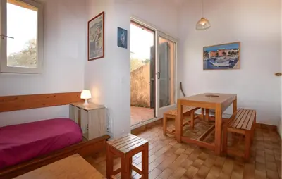 a bedroom with a bed and a table and a window at 2 Bedroom Cozy Home In Grosseto-Prugna in Grosseto-Prugna