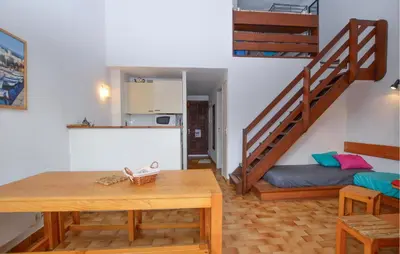 a living room with a table and a staircase at 2 Bedroom Cozy Home In Grosseto-Prugna in Grosseto-Prugna