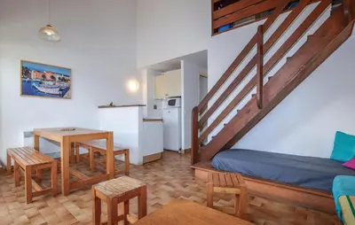 a room with a bed and a table and a kitchen at 2 Bedroom Cozy Home In Grosseto-Prugna in Grosseto-Prugna