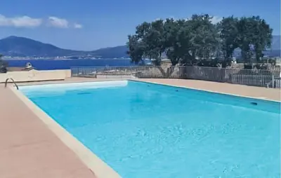 a blue swimming pool with a view of the water at 2 Bedroom Cozy Home In Grosseto-Prugna in Grosseto-Prugna