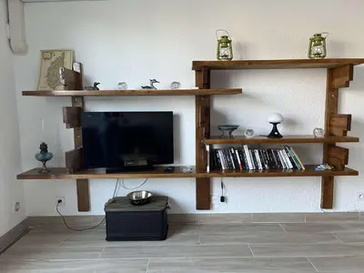 a living room with wooden shelves and a tv at BORGO Duplex 4 pers proche mer in Borgo