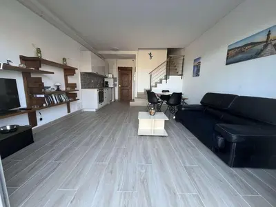 a living room with a black couch and a table at BORGO Duplex 4 pers proche mer in Borgo