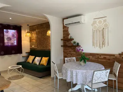a patio with a table and chairs and a dining room at Maison à 2min à pied du centre de porto vecchio in Porto-Vecchio