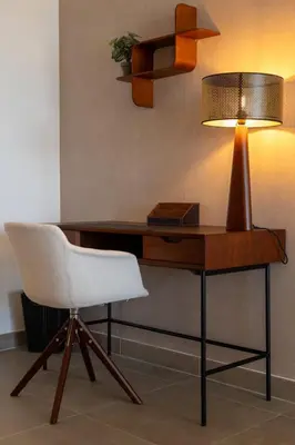 a desk with a lamp and a white chair at Agosta: Terrace with sea view - Luxury flat | By Airnest in Albitreccia