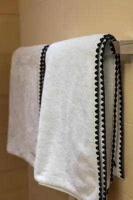 a towel hanging on a towel rack in a bathroom at Agosta: Terrace with sea view - Luxury flat | By Airnest in Albitreccia