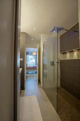 a bathroom with a walk in shower and a glass door at Agosta: Terrace with sea view - Luxury flat | By Airnest in Albitreccia