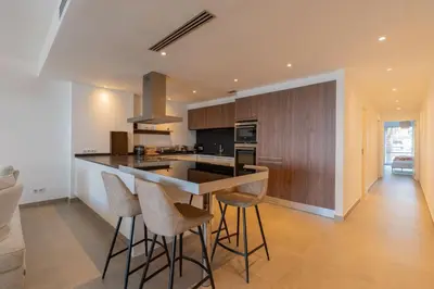 a kitchen with a counter and stools in a room at Agosta: Terrace with sea view - Luxury flat | By Airnest in Albitreccia