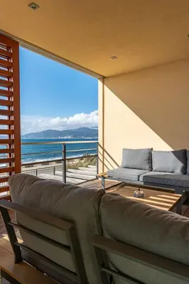 a living room with a couch and a view of the ocean at Agosta: Terrace with sea view - Luxury flat | By Airnest in Albitreccia