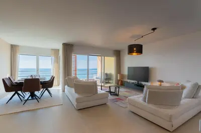a living room with a table and chairs and a dining room at Agosta: Terrace with sea view - Luxury flat | By Airnest in Albitreccia