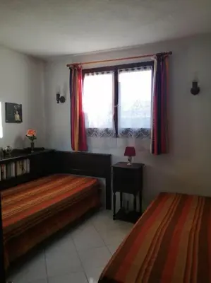 a bedroom with two beds and a window at Maison près de la plage in Penta-di-Casinca